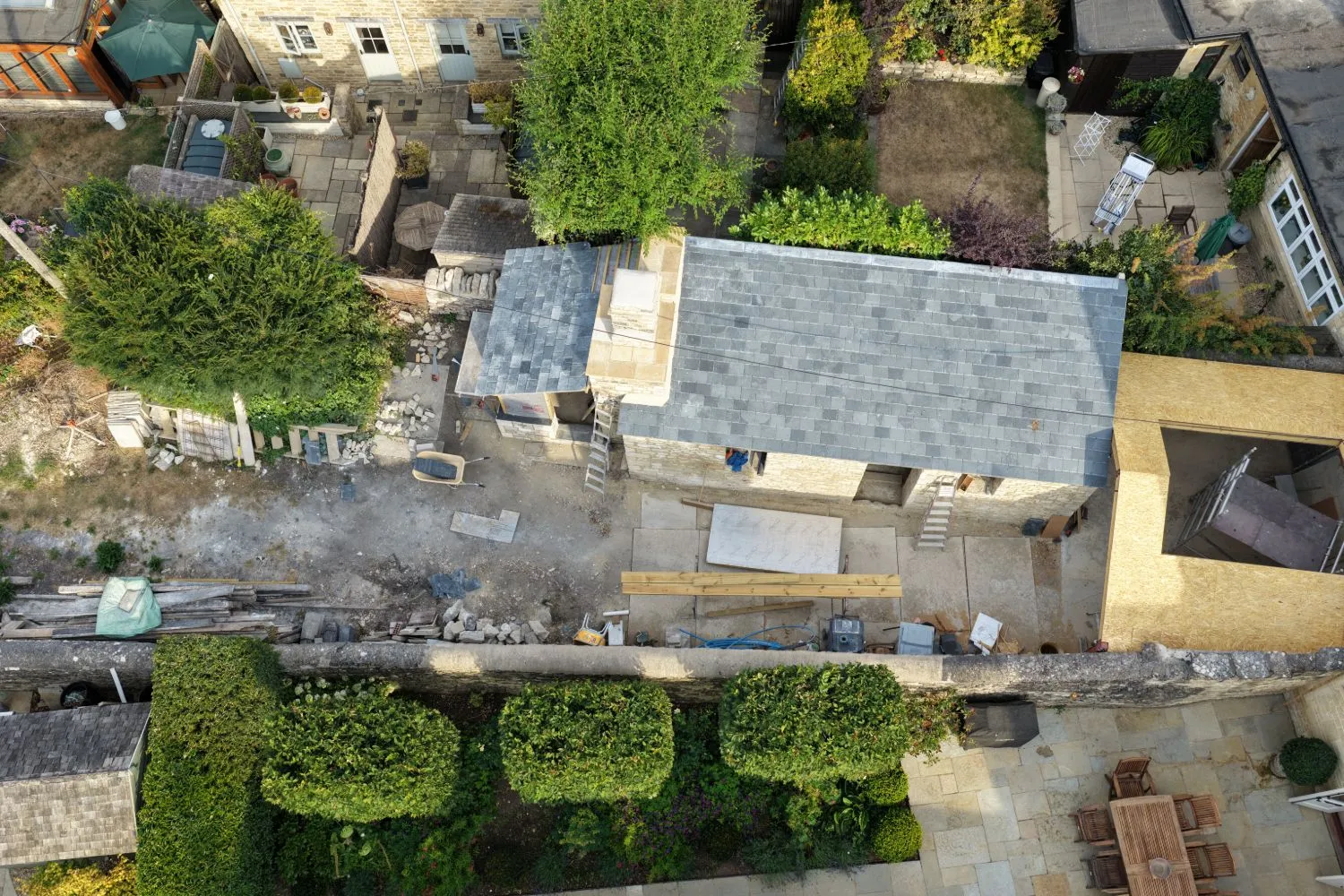 Aerial view of a stone cottage extension with the new slate roof completed