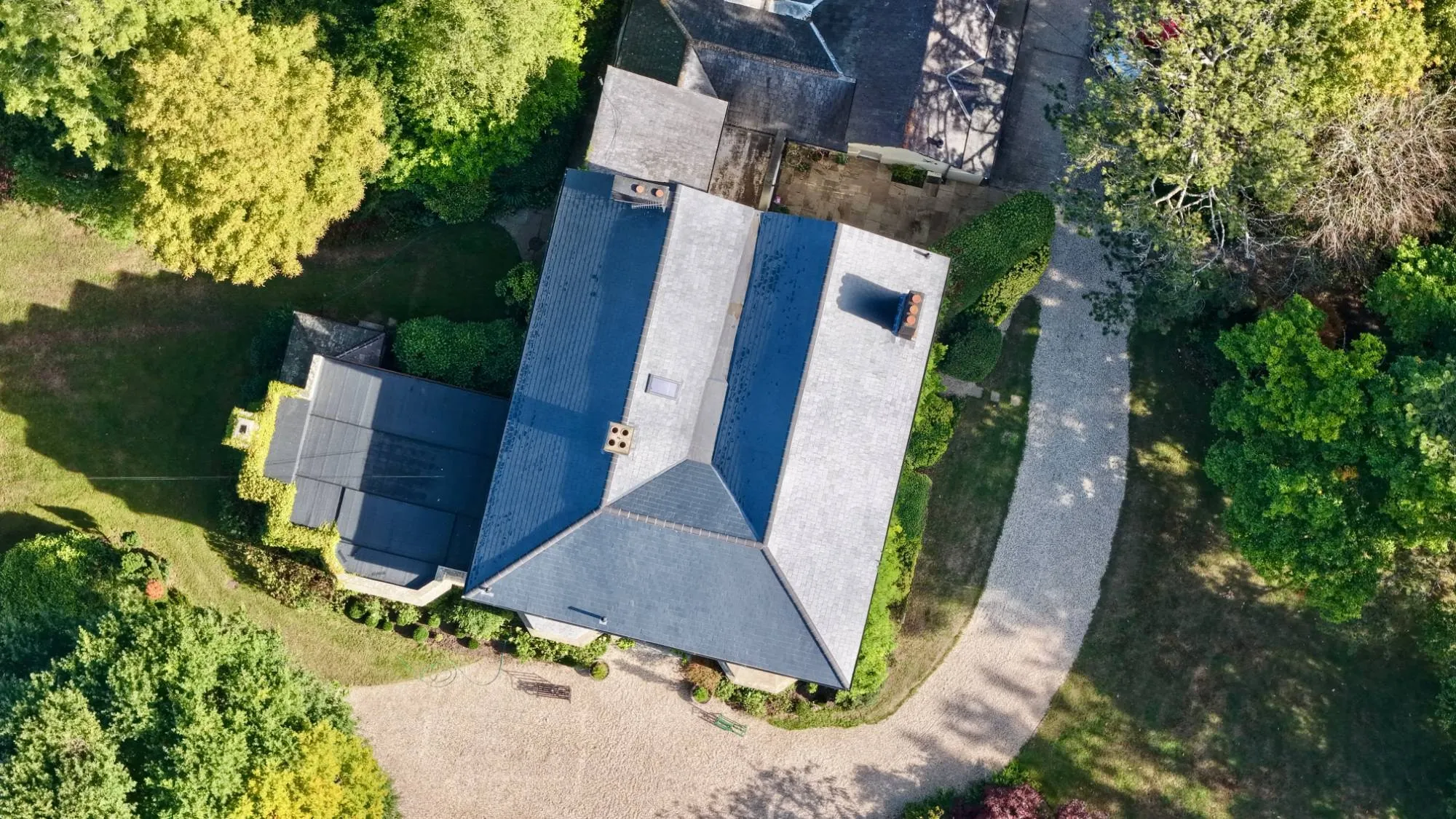 Top-down aerial view of a house's slate roof and chimneys